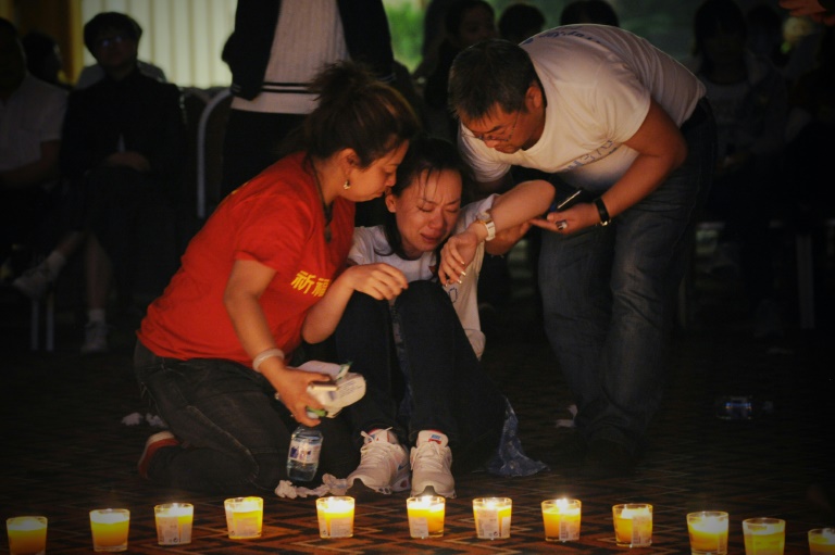 Des proches des passagers du Boeing 777 de Malaysia Airlines (vol MH370), le 8 avril 2014 à Pékin. © AFP