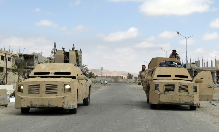 Des membres des forces syriennes dans des blindés à Palmyre, le 27 mars 2016 . © AFP