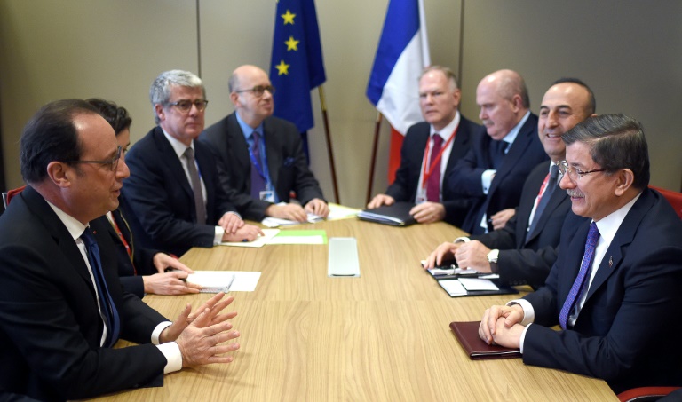 Le president français François Hollande (g) rencontre le Premier ministre turc Ahmet Davutoglu (d) et le ministre des Affaires étrangères Mevlut Cavusoglu (2e à d), à Bruxelles le 18 mars 2016. © AFP