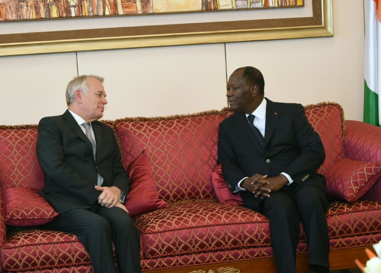 Le président ivoirien Alassane Ouattara(d) parle avec le ministre français des Affaires étrangères Jean-Marc Ayrault à Abidjan le 15 mars 2016. © AFP