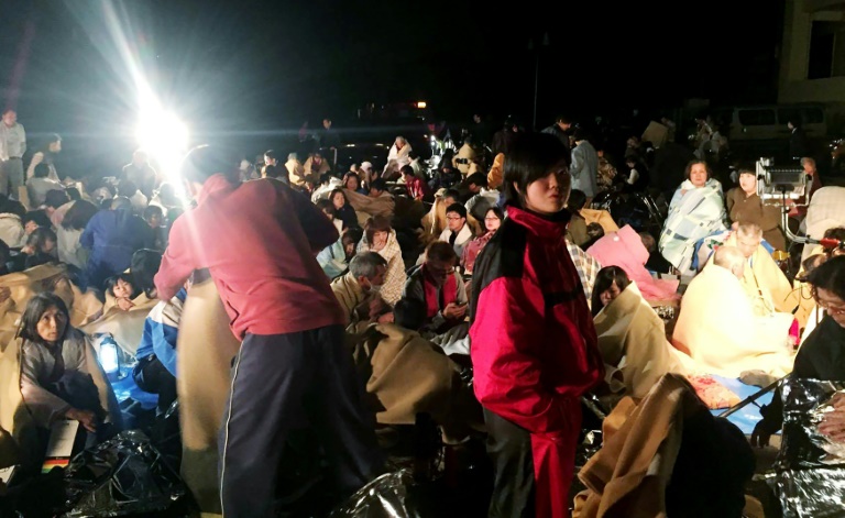 Des gens se réunissent dans un abri devant la mairie de Mashiki, dans la préfecture japonaise de Kumamoto après un tremblement de terre, le 14 avril 2016. © AFP