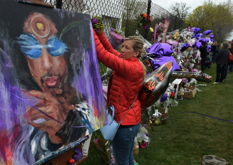 Une fan attache des fleurs en hommage à Prince à Minneapolis, le 22 avril 2016. © AFP