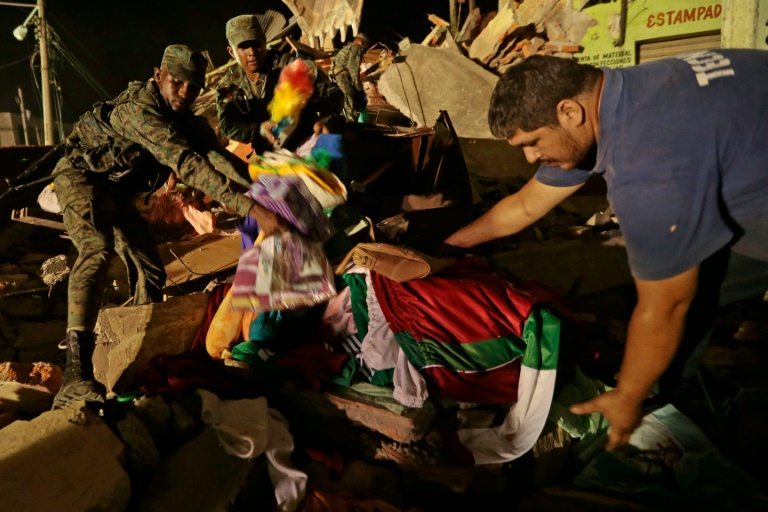 Des sauveteurs au milieu des décombres le 18 avril 2016 à Portoviejo . © AFP